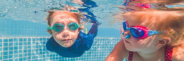 Kids having fun playing underwater in swimming pool on summer vacation BANNER, LONG FORMAT - Фото, изображение