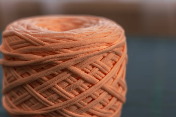 A coil of large knitted yarn of peach color on the blure backgroud - Photo, image