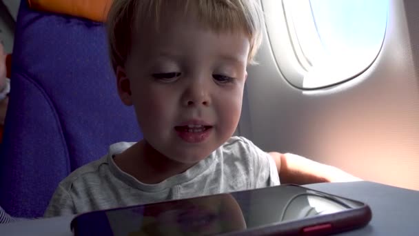 Child watching smartphone in airplane - Footage, Video