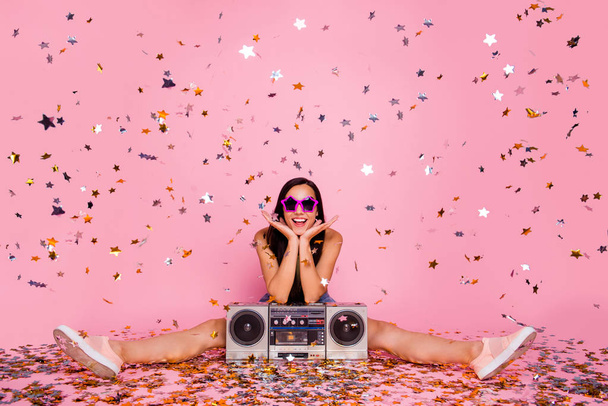 Portrait of her she nice-looking lovely attractive cheerful cheery positive girl sitting on floor having fun time event holiday flying decorative elements isolated over pink pastel background - Foto, immagini