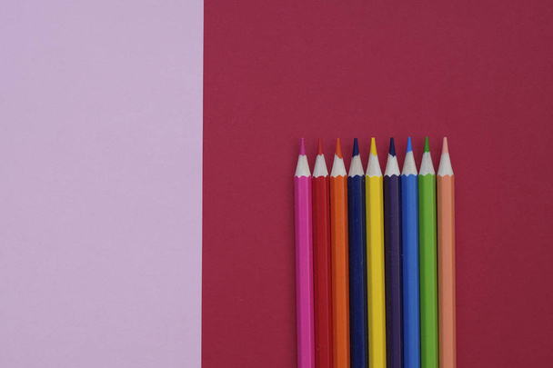 Fondo de papel geométrico abstracto con lápices de color. Colores de moda rosa y coral. Concepto de escuela y educación
. - Foto, imagen