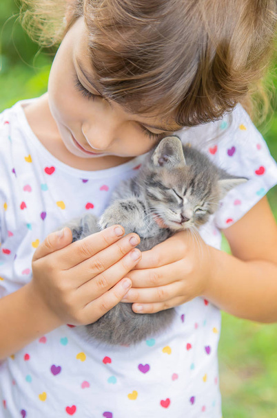 Kis cica a gyerekek kezében. Szelektív fókusz. - Fotó, kép