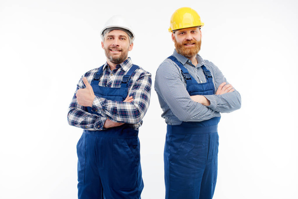 Two engineers smiling at camera on white background - Φωτογραφία, εικόνα