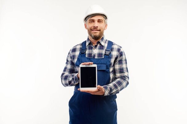 Engineer shows tablet to the camera on a white background. - Fotoğraf, Görsel