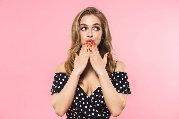 Beautiful excited young pretty woman posing isolated over pink wall background covering mouth. - Φωτογραφία, εικόνα