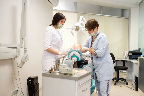 Dentist and nurse making professional teeth cleaning male senior patient at the dental office. Dental care for older people. Dentistry, medicine and health care concept - Valokuva, kuva
