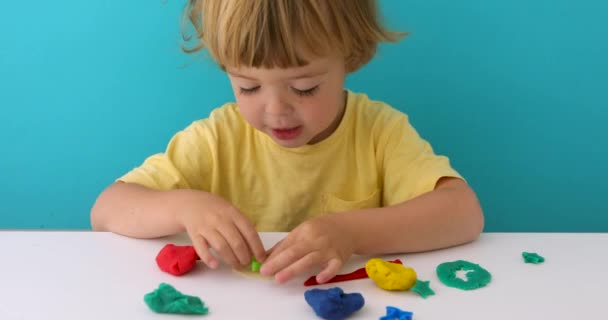Charming boy with play dough at table - Footage, Video
