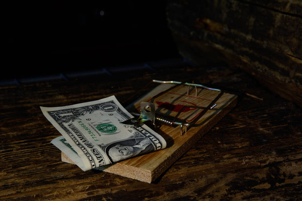 Nella trappola per topi in legno c'è una banconota da dieci euro su uno sfondo scuro. Concetto - transazioni finanziarie rischiose, frode, investimenti rischiosi. "Non esiste un pranzo gratis
." - Foto, immagini