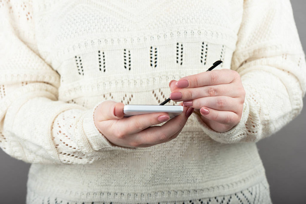 Woman using white smartphone with stylus. - Zdjęcie, obraz