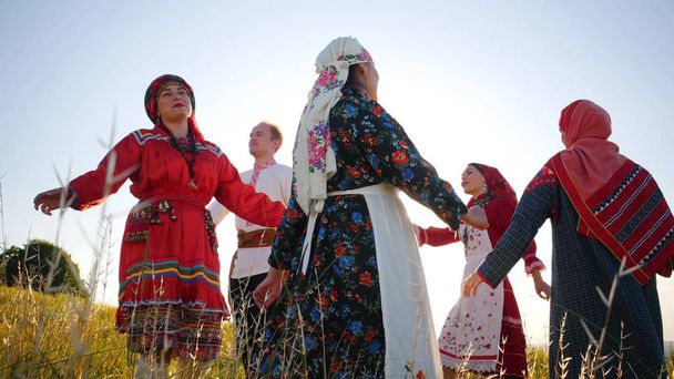 Persone in abiti tradizionali russi che eseguono una danza rotonda sul campo
 - Foto, immagini