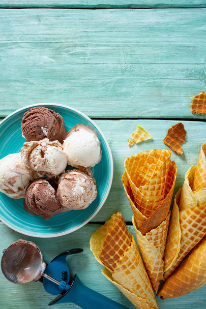 ice cream and waffle cones on turquoise wooden surface - Фото, зображення