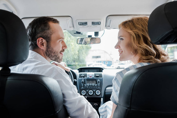 selektywne skupienie szczęśliwego mężczyzny patrząc na wesoły Kobieta w samochodzie  - Zdjęcie, obraz