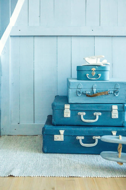 Blue Suitcases on the floor in the nursery kids room. Decorative storage of things. - 写真・画像