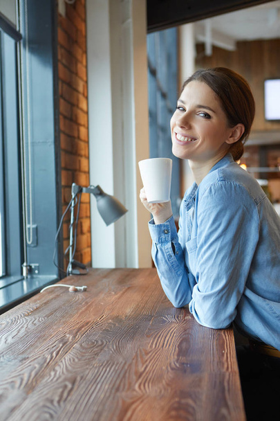 A young woman having coffee in office - Fotoğraf, Görsel