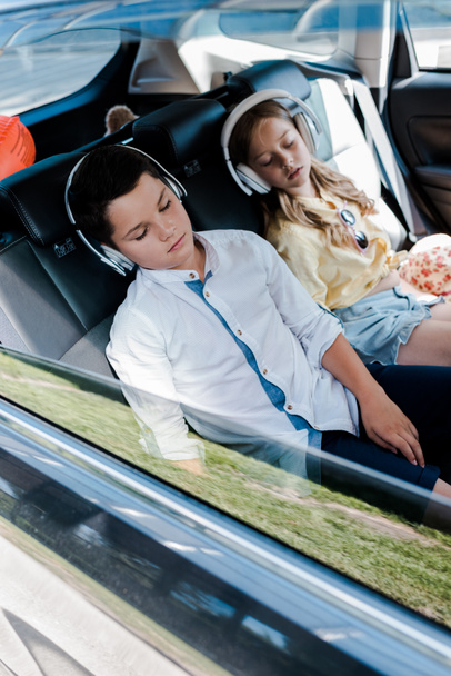 foyer sélectif des enfants mignons dans les écouteurs dormir dans la voiture
  - Photo, image