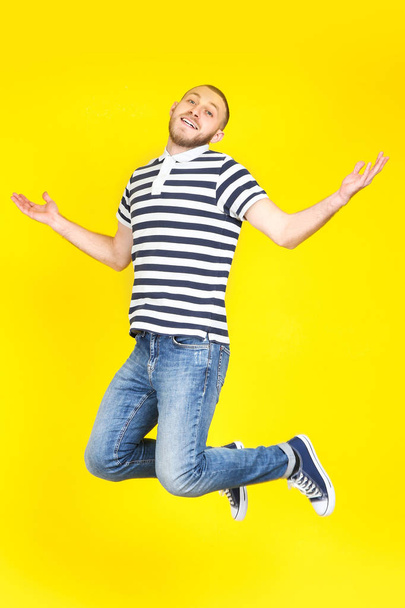 Jumping young man on yellow background - Foto, Imagem