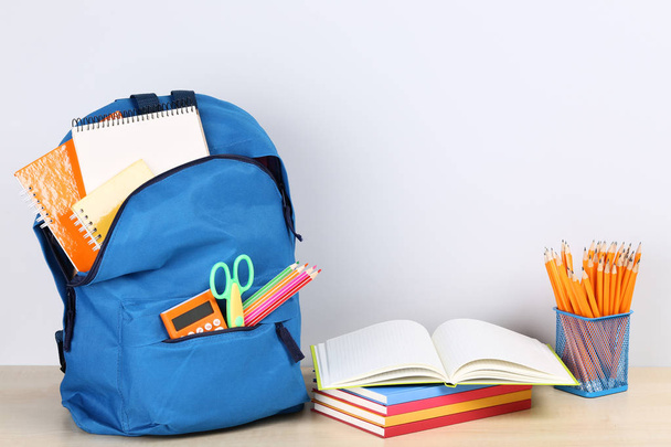 Backpack with school supplies on grey background - Fotoğraf, Görsel
