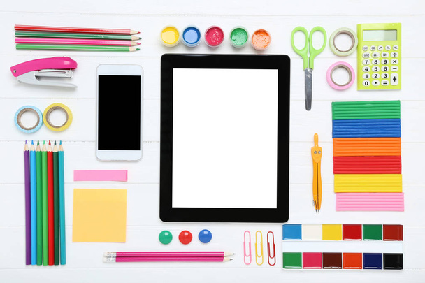 School supplies with smartphone and tablet on white wooden table - Photo, image
