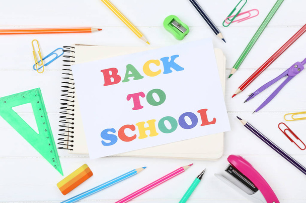 Text Back To School with stationery on white wooden table - Foto, Bild