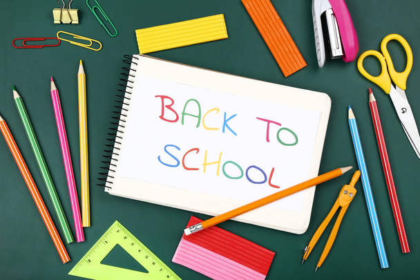 Text Back To School with stationery on green background - Foto, Bild