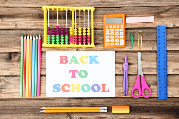 Text Back To School with stationery on brown wooden table - Foto, Bild