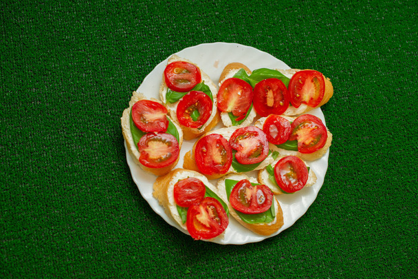 Aşçı domates ile ekmek üzerine süzme peynir yayılır . - Fotoğraf, Görsel