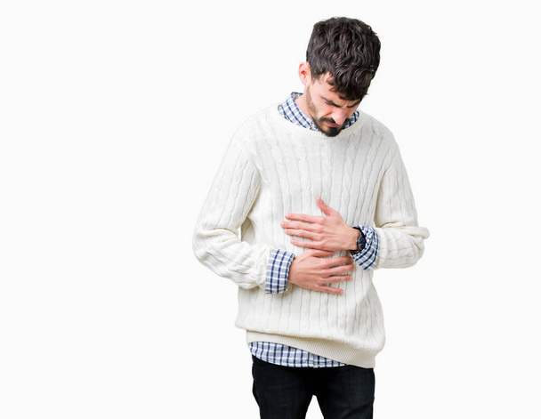 Young handsome man wearing winter sweater over isolated background with hand on stomach because nausea, painful disease feeling unwell. Ache concept. - Photo, image