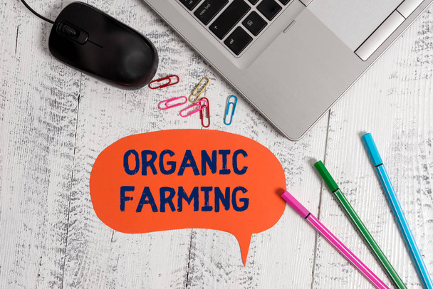 Text sign showing Organic Farming. Conceptual photo an integrated farming system that strives for sustainability Metallic slim laptop speech bubble colored clips pens mouse wooden vintage. - Photo, Image