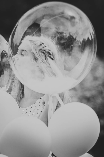 black white photo young girl with balloons on nature background - Foto, Imagen