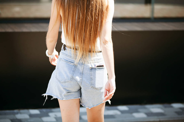 Sexy back of a girl in denim shorts on the street. - Fotoğraf, Görsel