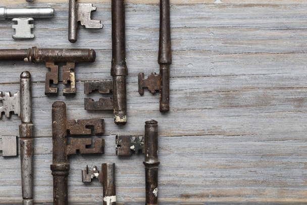 Vintage old fashioned keys on a rustic wooden background. Security concept - Fotografie, Obrázek
