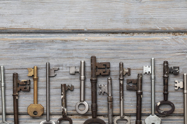 Vintage old fashioned keys on a rustic wooden background. Security concept - Foto, Imagem