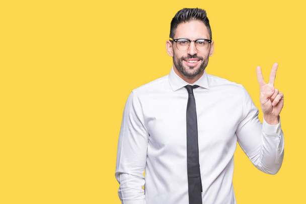 Young handsome business man wearing glasses over isolated background showing and pointing up with fingers number two while smiling confident and happy. - Photo, Image