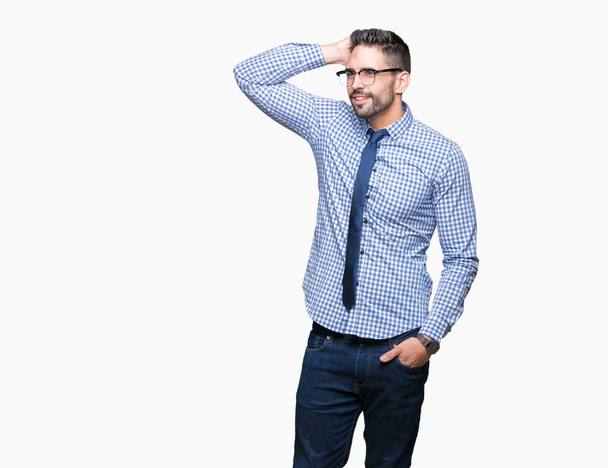 Νέοι επαγγελματίες άνδρα που φοράει γυαλιά πέρα από το απομονωμένο υπόβαθρο χαμογελώντας αυτοπεποίθηση συγκινητικό τρίχα με το χέρι σε χειρονομία, θέτοντας ελκυστική - Φωτογραφία, εικόνα