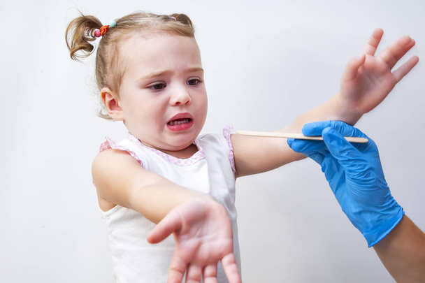 Little cute girl fearing of pediatrician examining - Foto, imagen