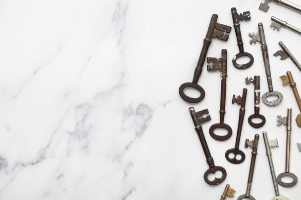 Vintage old fashioned keys on a marble background with copy space - Fotoğraf, Görsel