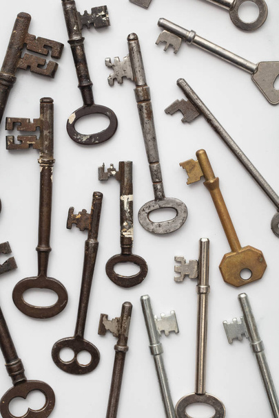 Large set of vintage keys on a plain background. Safety and security concept - Фото, изображение