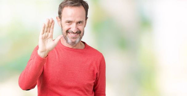 Красивий чоловік середнього віку в зимовому светрі над ізольованим тлом Очікування привітання щасливий і усміхнений, доброзичливий вітальний жест
 - Фото, зображення