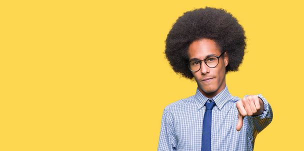 Νεαρός αφρικανική αμερικανική επιχείρηση άνθρωπος με τα Άφρο μαλλιά που φοράει γυαλιά αναζητούν δυστυχισμένοι και θυμωμένος εμφάνιση απόρριψη και αρνητικά με αντίχειρες προς τα κάτω κίνηση. Κακή έκφραση. - Φωτογραφία, εικόνα