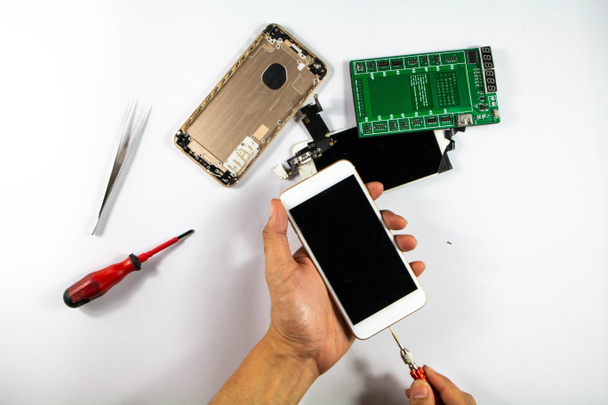 Il riparatore mobile sta iniziando a controllare il telefono cellulare danneggiato. E portato in riparazione
 - Foto, immagini