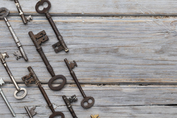 Vintage old fashioned keys on a rustic wooden background. Security concept - Zdjęcie, obraz