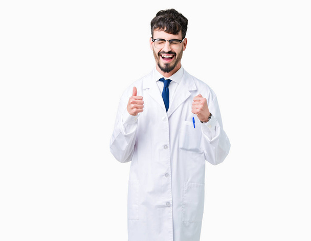 Fiatal szakmai tudós ember visel fehér kabát fölött elszigetelt háttér izgatott a siker a karok emelt ünneplése győzelem mosolyogva. Győztes koncepció. - Fotó, kép