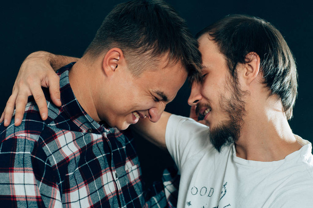 two guys hugging on a dark background - Foto, afbeelding