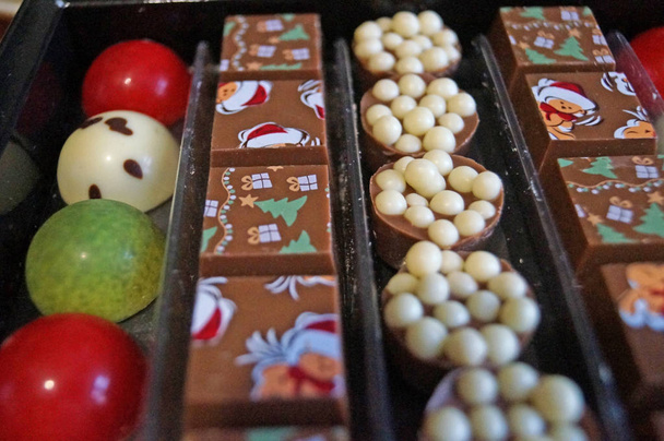 箱の中に多色の釉薬を持つお祝いの新年のチョコレート - 写真・画像