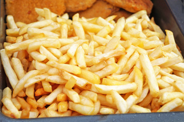 Рудний хрусткий смажений картопля фрі на тарілці на столі
 - Фото, зображення