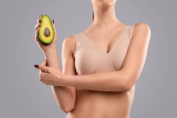 Crop female demonstrating avocado - Foto, Imagen