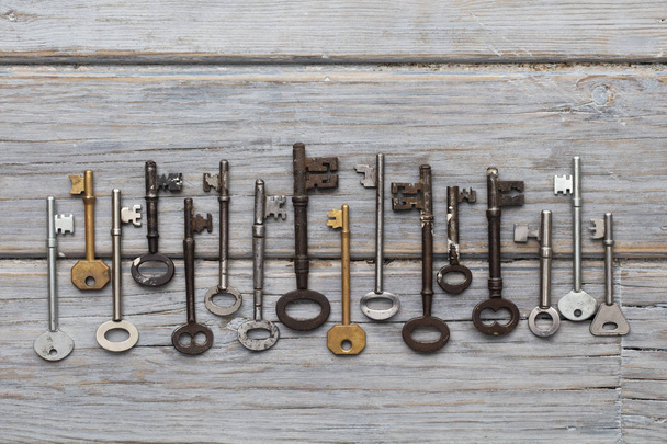 Vintage old fashioned keys on a rustic wooden background. Security concept - 写真・画像