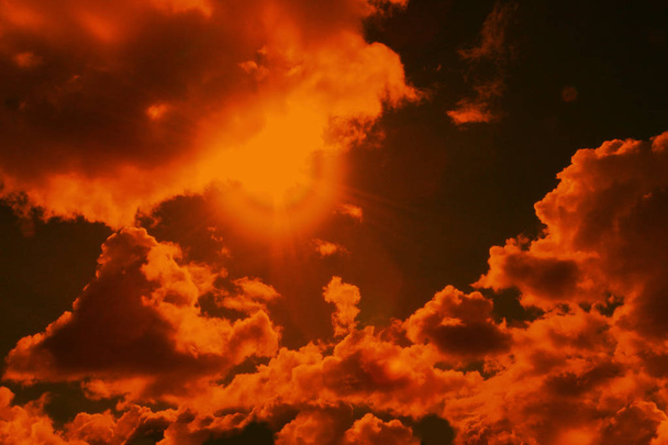 tinted orange photograph of the sky with clouds and sun with highlights, the concept of the summer heat, preparation for the designer, close-up - Foto, immagini