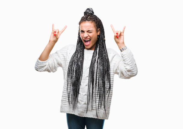 Fiatal fonott haj afro-amerikai lány visel pulóver, mint őrült kifejezés csinál rock szimbólum kézzel kiabálás elszigetelt háttér. Zene csillag. Nehéz koncepció. - Fotó, kép