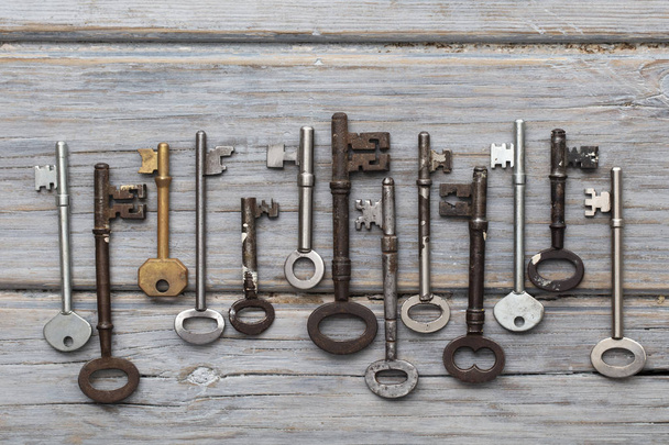 Vintage old fashioned keys on a rustic wooden background. Security concept - Фото, изображение